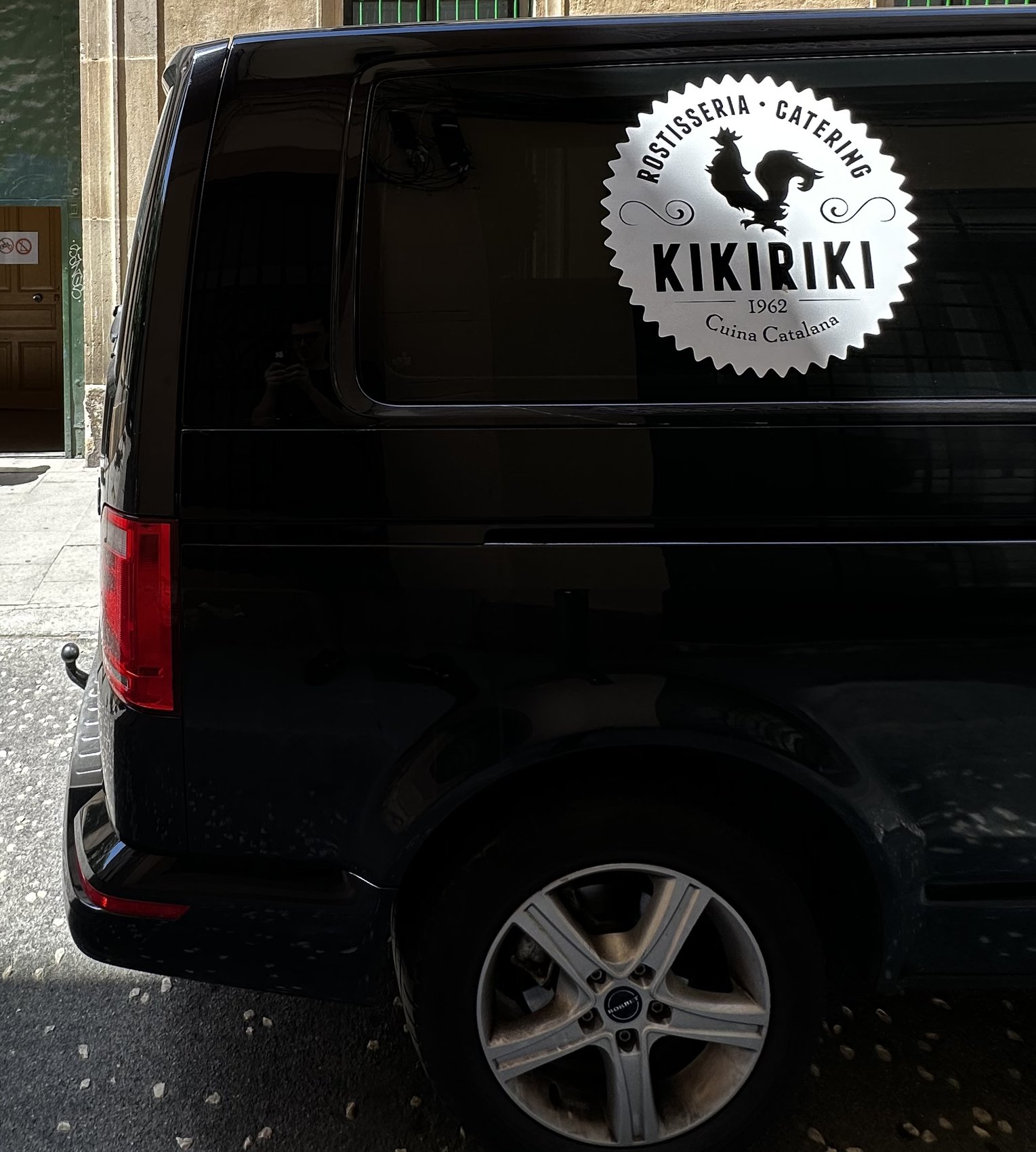 La furgoneta del càtering Kikiriki al carrer, amb el segell a la lluna del darrere